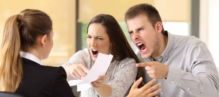 Angry couple claiming and shouting to an office worker